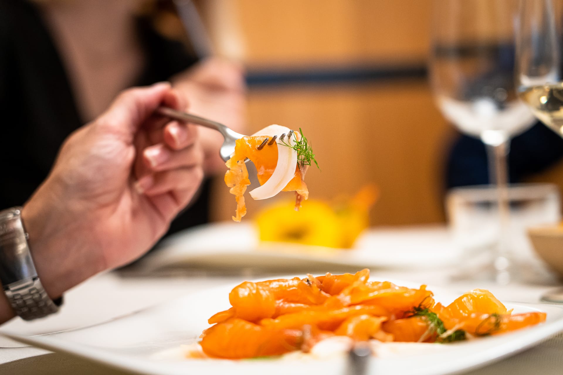 Persona che mangia un piatto di salmone affumicato con aneto e finocchi